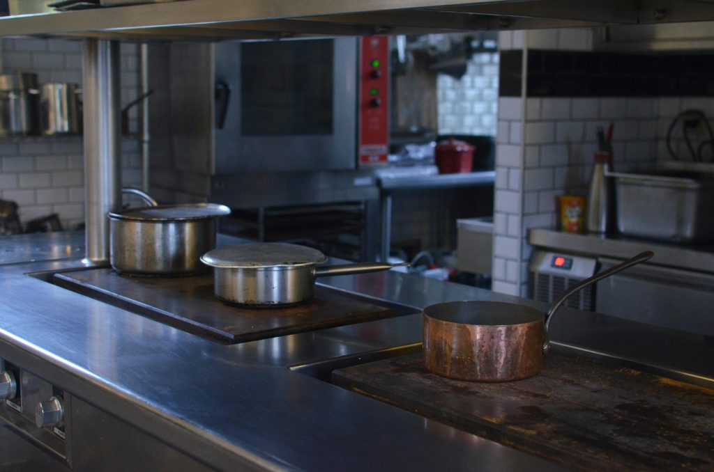 Stainless steel pots on the counter of a professional kitchen